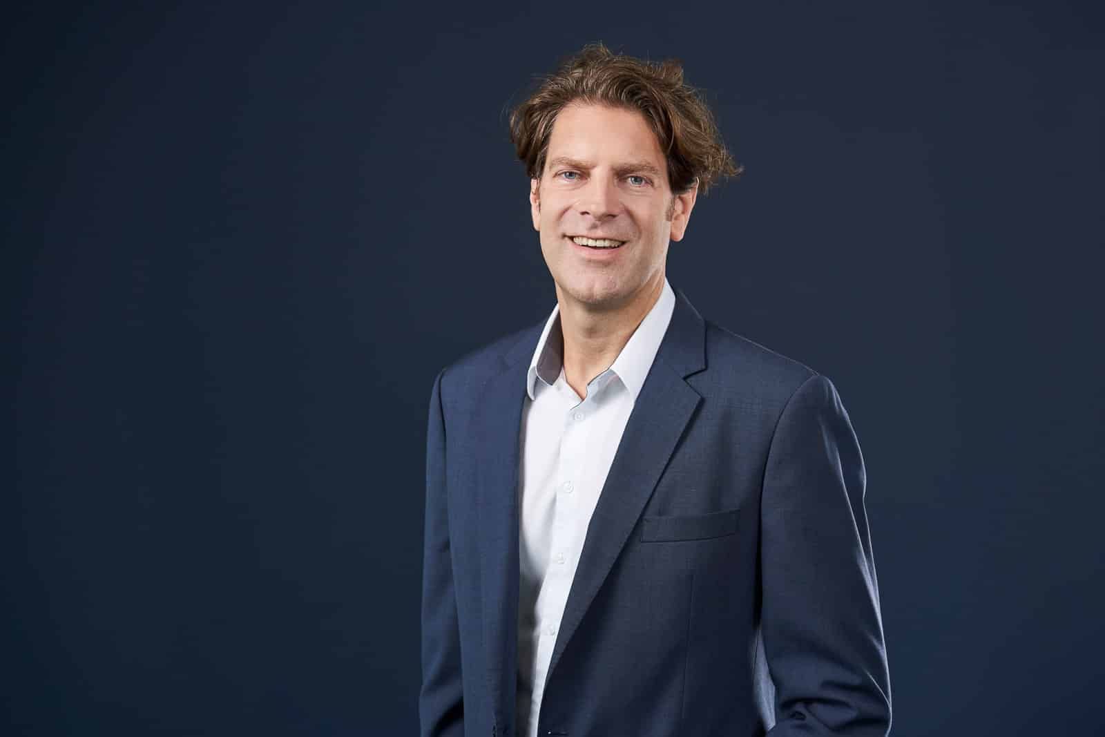 Home 18 Business-Portrait eines Mannes im dunklen Anzug.