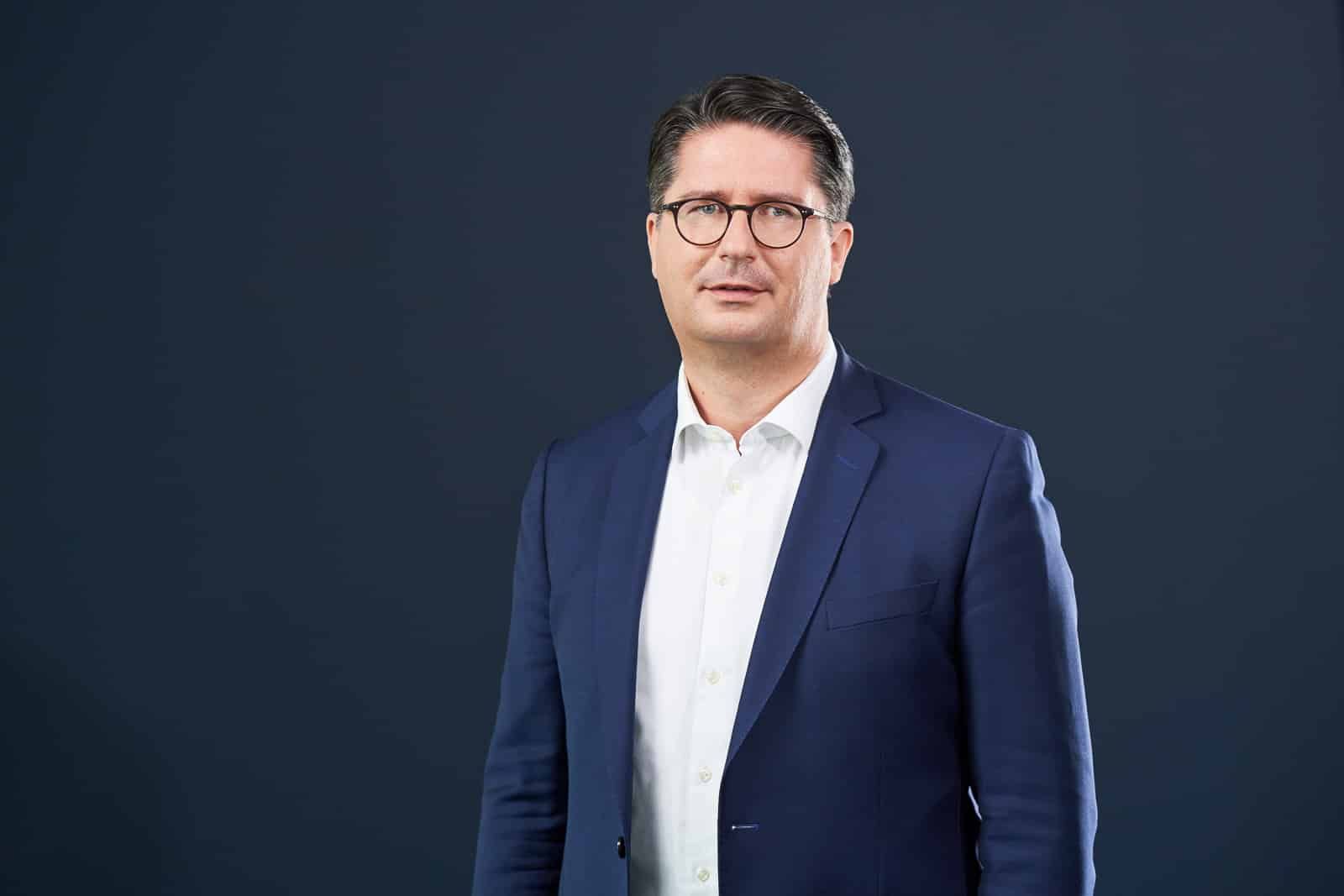 Home 20 Business-Portrait eines Mannes im dunklen Anzug.