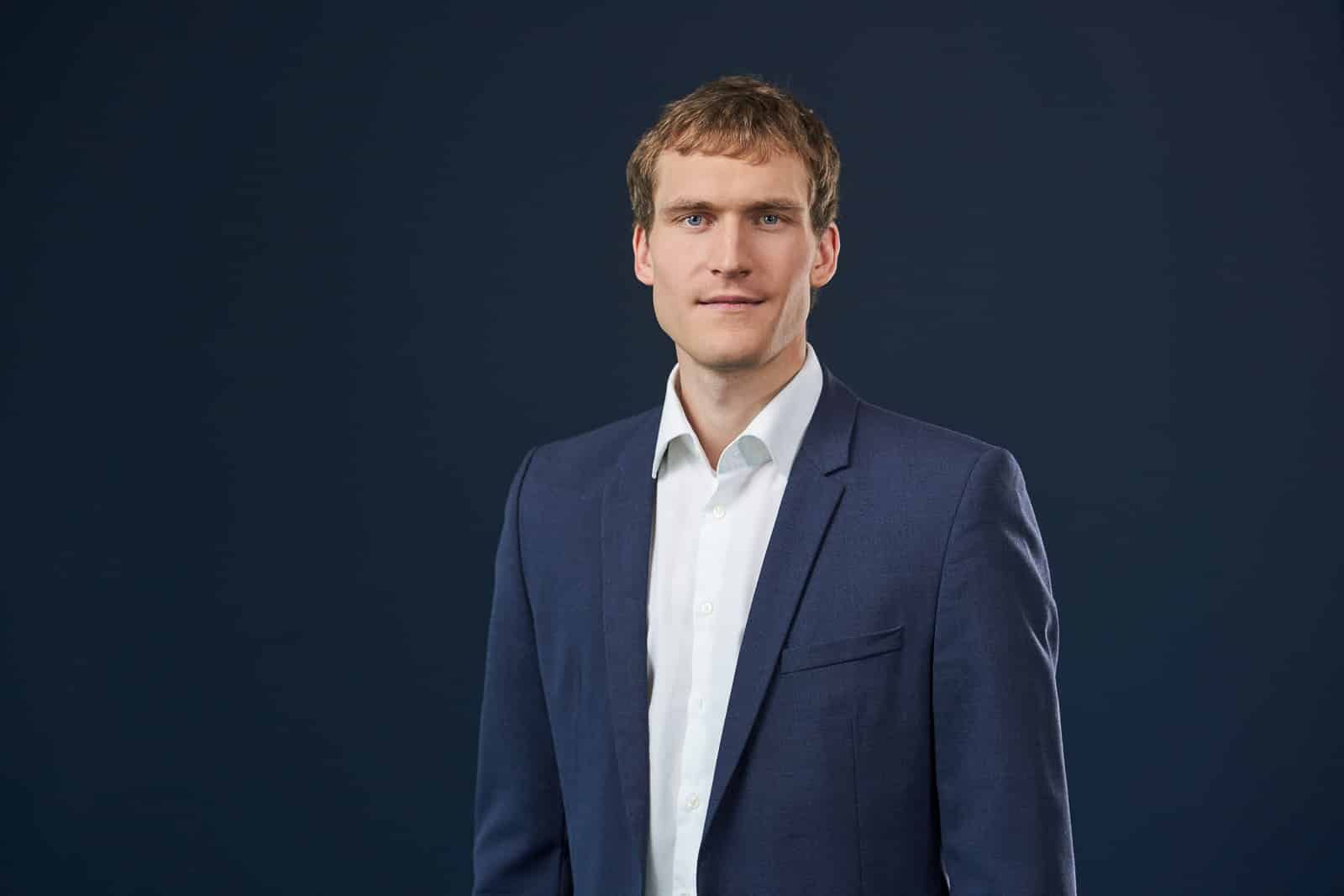 Home 22 Business-Portrait eines Mannes im dunklen Anzug.