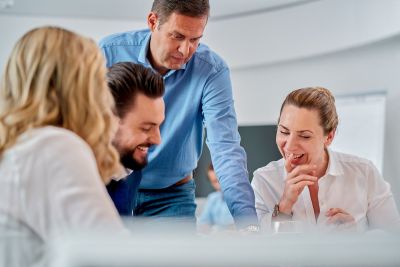 Home 8 Corporatefotografie - Gesprächssituation. Geschäftsführer unterhält sich mit Mitarbeitern.