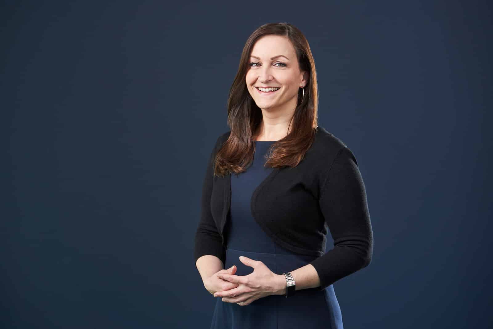 Home 19 Business-Portrait einer jungen Frau. Sie lächelt in die Kamera.