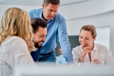 Home 8 Corporatefotografie - Gesprächssituation. Geschäftsführer unterhält sich mit Mitarbeitern.